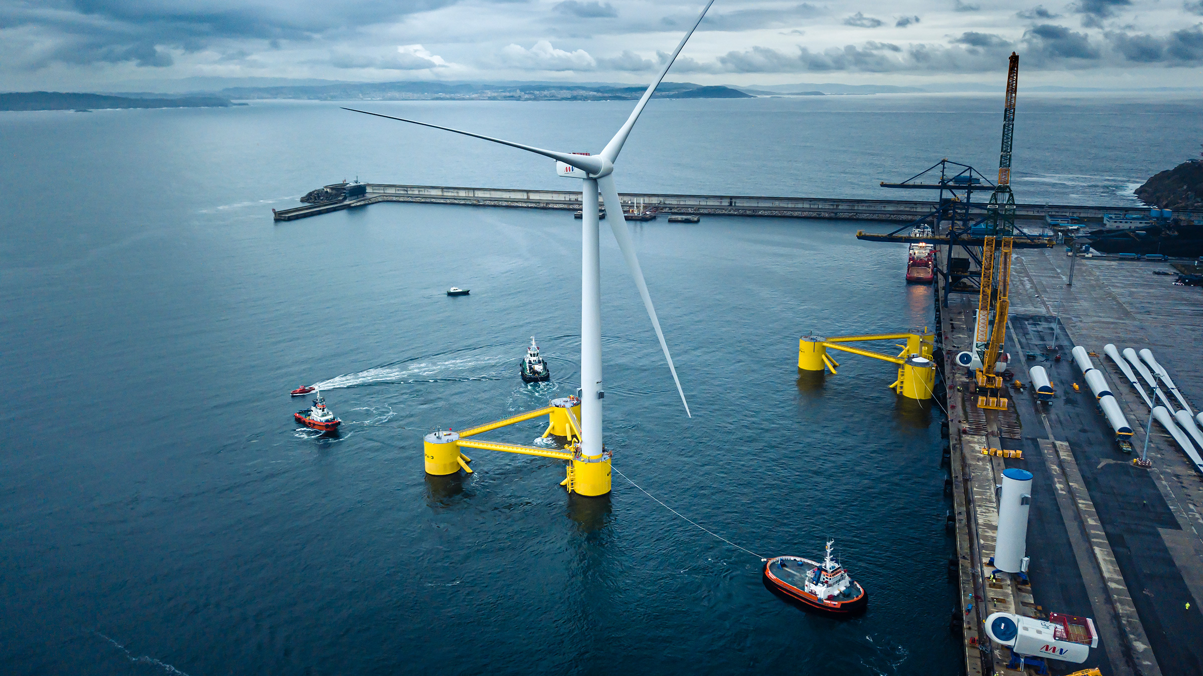 An assembled floating offshore wind turbine starting its tow-out for the WindFloat Atlantic project.